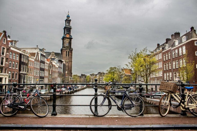 Kanal i Amsterdam med cyklar parkerade på en bro