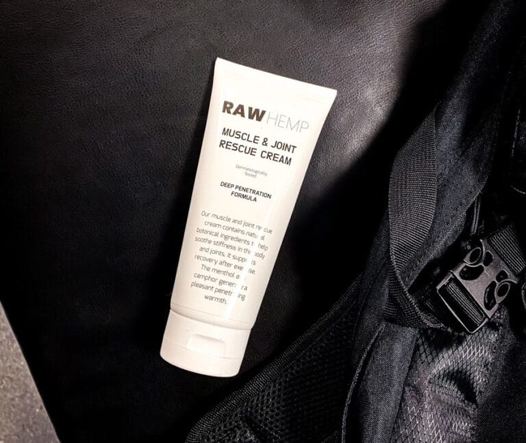 Tub med Raw Hemp Muscle & Joint Cream, ett CBD-liniment, på en träningsväska