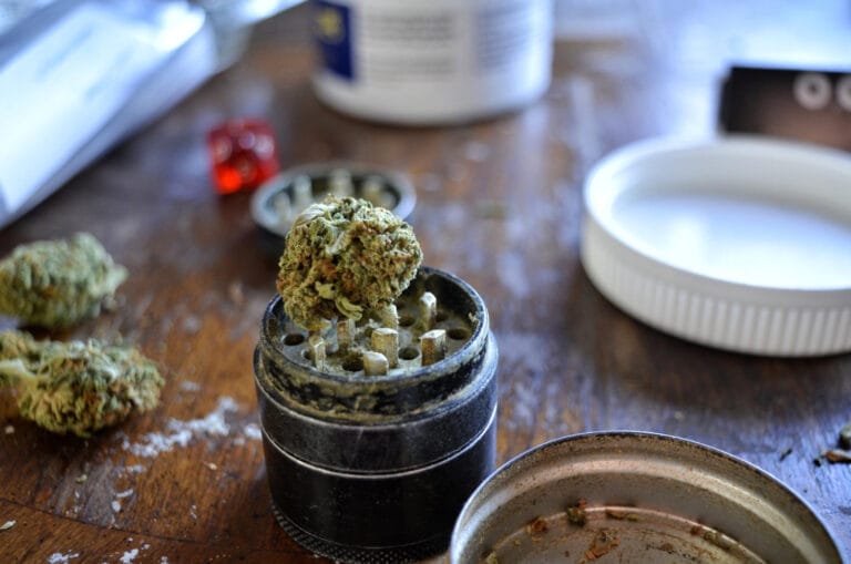 cannabis, grinder och ocb i bakgrunden