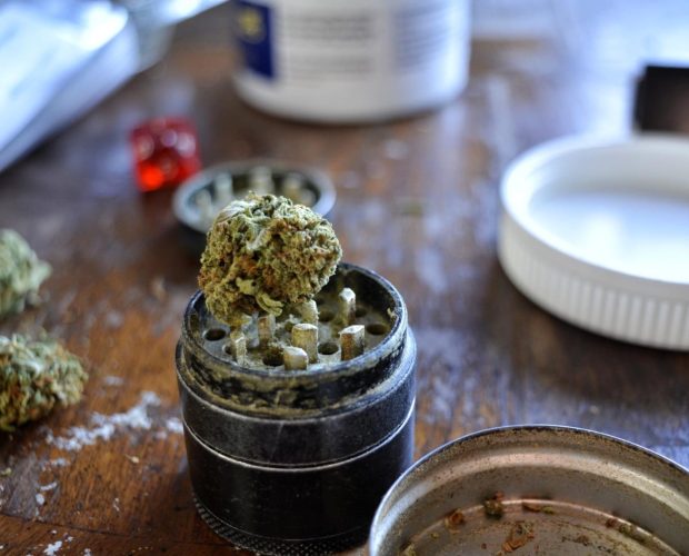 cannabis, grinder och ocb i bakgrunden
